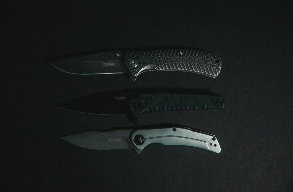 three pocket knives lining in black background