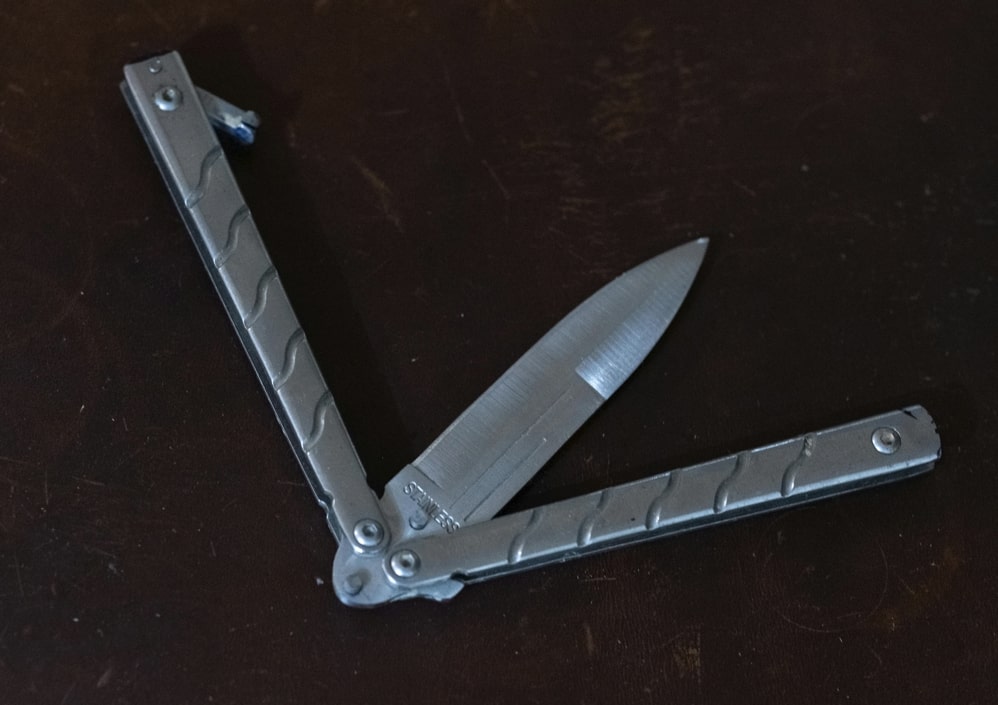 an opening balisong or butterfly knife on the desk