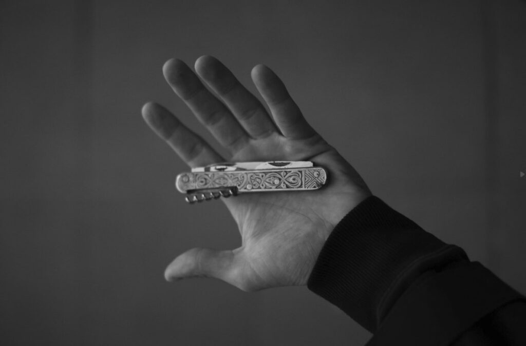 man holding a folding pocket knife in clear background